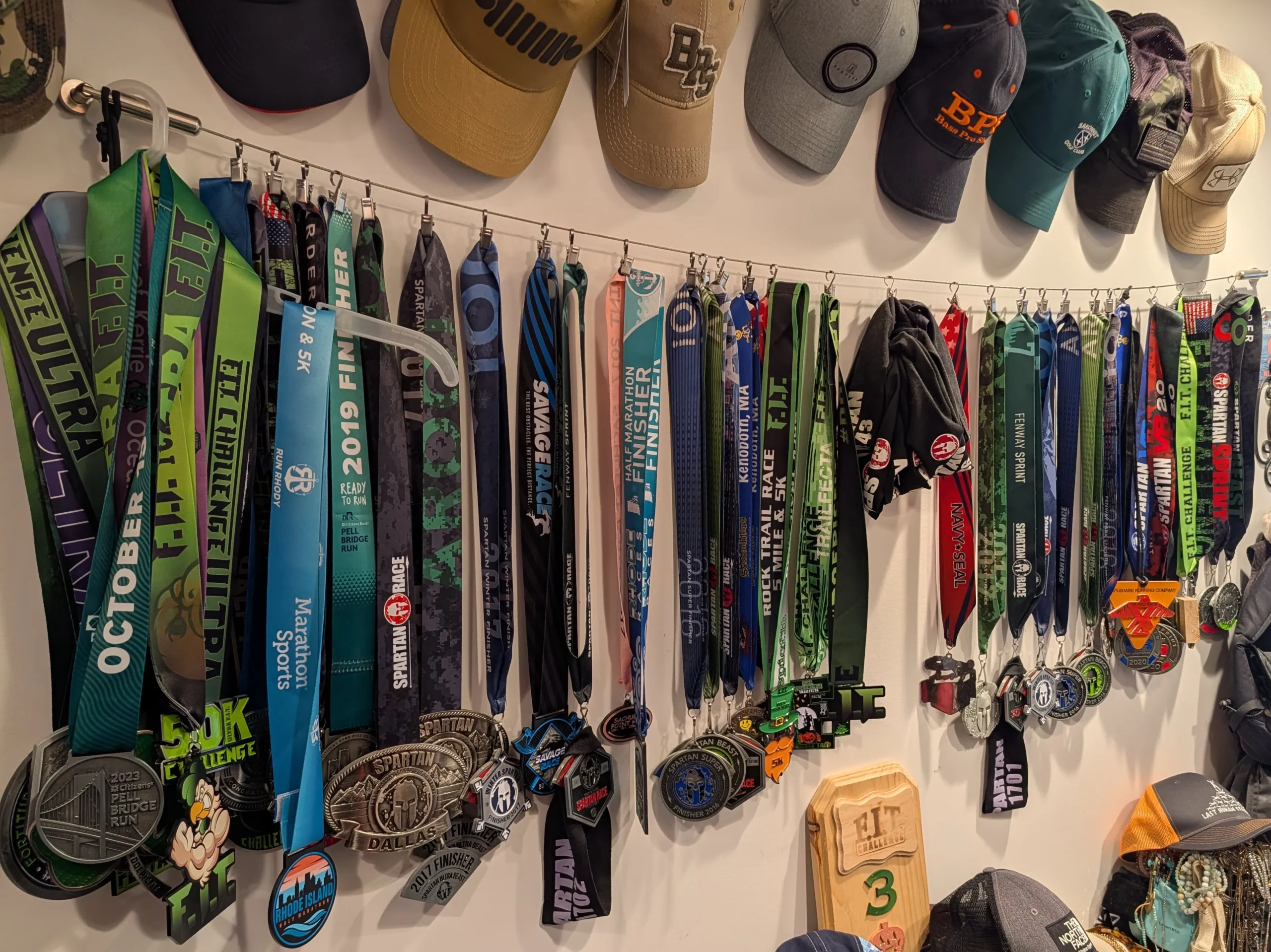 Metals from past races hanging from the wall. Ranging from a 5K to 50 miler ultra marathon